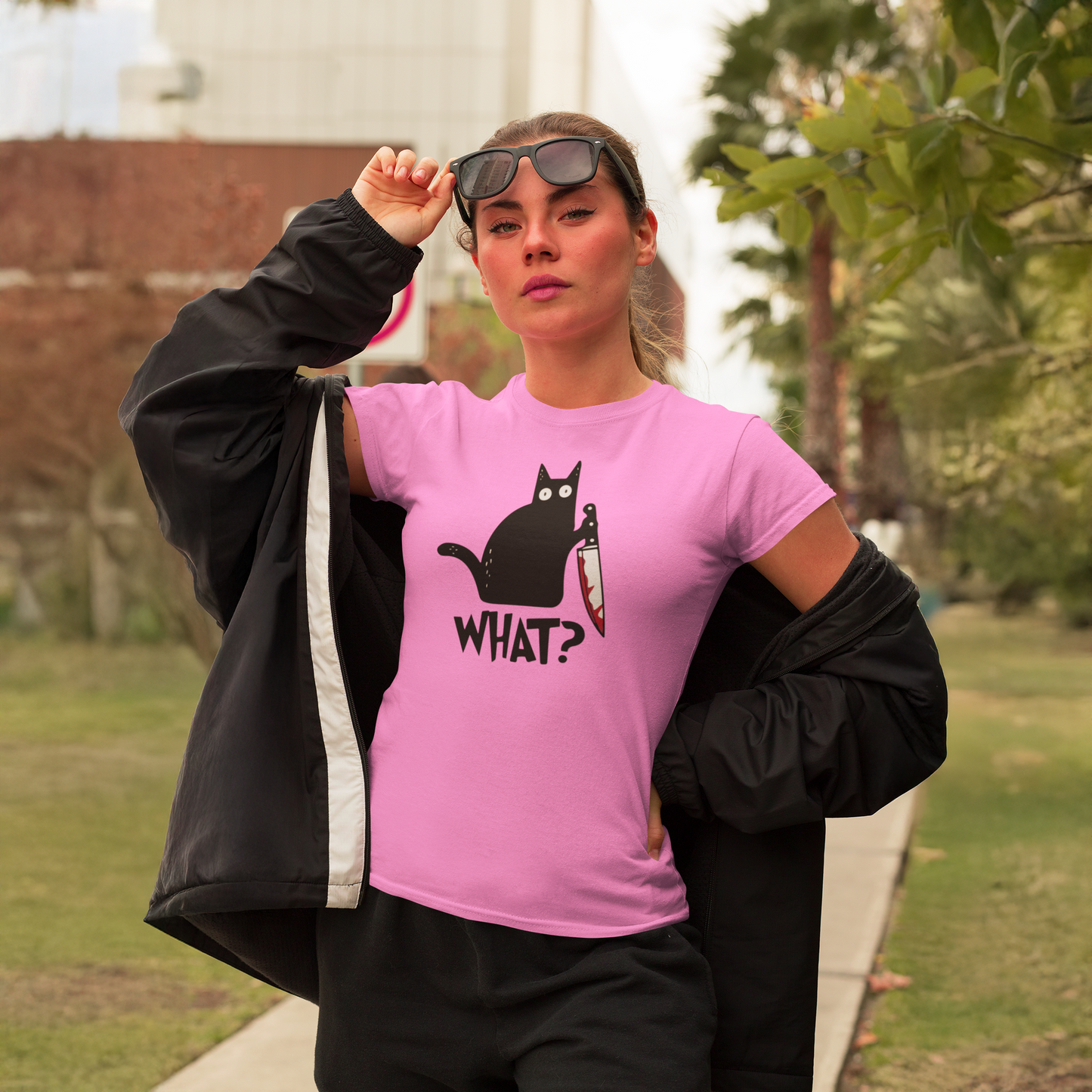 Woman with bright pink tee shirt and funny cat holding knife.